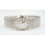 A lady's late 1950's 9ct. white gold Longines manual wrist watch, with integral 9ct white gold