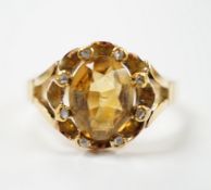 An 18ct and single stone oval cut citrine set dress ring, with eight stone diamond chip set