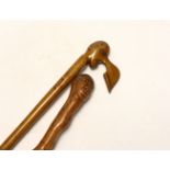 Two walking canes including a Greek olive wood example with carved head handle, largest 89cm in