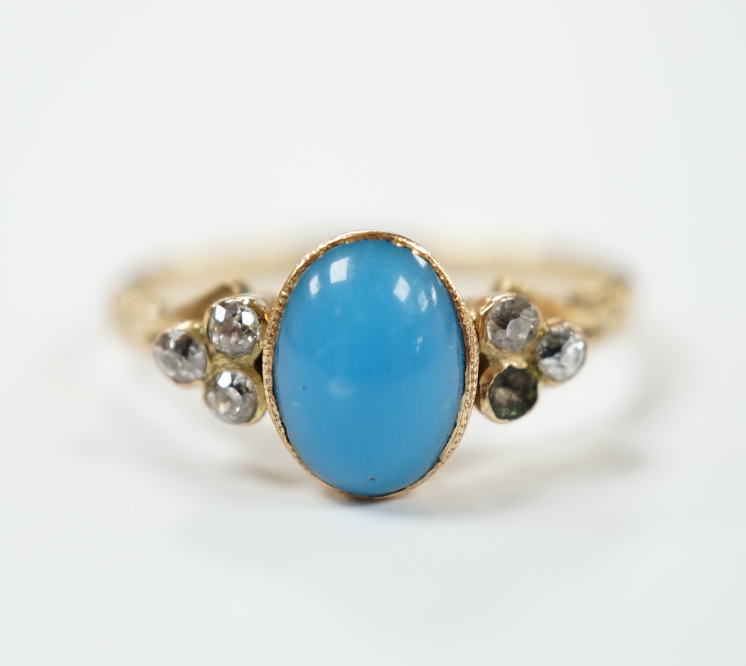 A yellow metal and single stone cabochon turquoise set ring, with six stone diamond set shoulders (