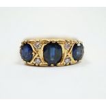 An 18ct and three stone sapphire set half hoop ring, with diamond chip spacers, size O, gross weight