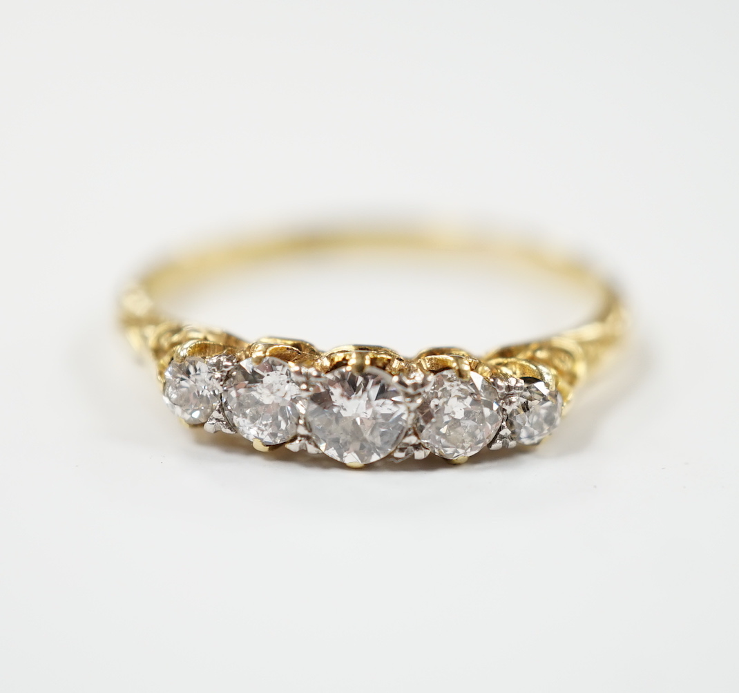 An 18ct and graduated five stone diamond set half hoop ring, size P/Q, gross weight 2.7 grams.