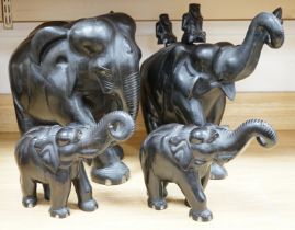 Two large carved ebony elephants and two smaller similar elephants