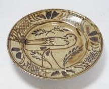A Seth Cardew studio pottery stoneware dish, decorated with a bird and stylised flowers, 28cm in