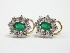 A modern pair of 18ct gold, emerald and diamond set oval cluster earrings, 13mm, gross weight 5.3