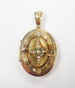A late Victorian engraved yellow metal, seed pearl and gem set oval locket, overall 50mm, gross