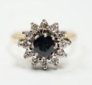 An 18ct, sapphire and diamond set circular cluster ring, size N, gross weight 3.9 grams.