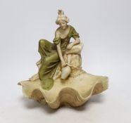 A Royal Dux figure of a water carrier by a shell shaped pool, 26cm high