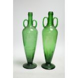 A pair of double handle green glass vases, 33cm