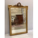 A 19th century French giltwood and composition wall mirror, with floral scroll pediment, width