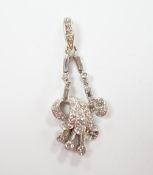 A white metal baguette and round cut diamond cluster set scroll pendant, overall 33mm, gross