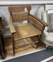 An Arts and Crafts style oak elbow chair with rush seat and back, width 60cm, depth 44cm, height