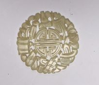 A Chinese carved pale celadon disc, 5.5cm in diameter