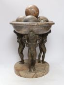 A reconstituted marble and bronzed metal Atlas tazza centrepiece with four stone spheres, 49cm high
