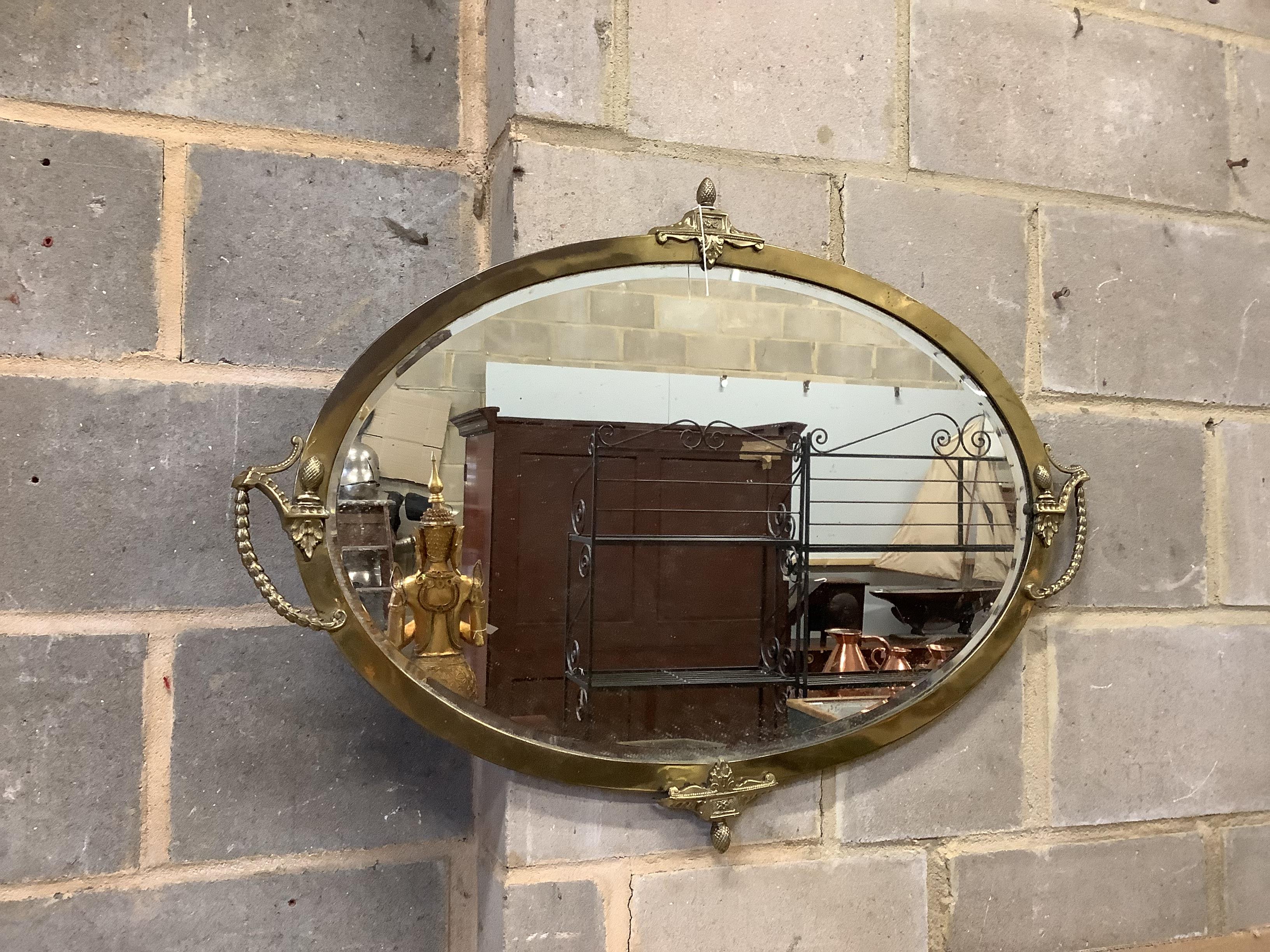 An Edwardian oval brass wall mirror width 87cm, height 64cm.