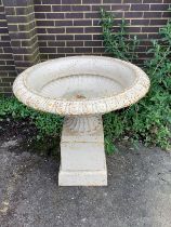 A Victorian style circular cast iron campana garden urn on square plinth, diameter 95cm, height