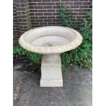 A Victorian style circular cast iron campana garden urn on square plinth, diameter 95cm, height