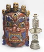 A Tibetan painted wood mask and a cast pewter candlestick, mask 44cm high