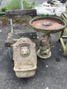 A composition faux marble lion mask wall fountain, a slatted wrought iron garden chair and a