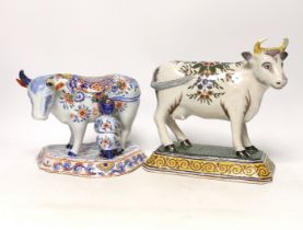 Two 19th century Delft models of cows, one with milkmaid, tallest 22cm