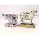 Two 19th century Delft models of cows, one with milkmaid, tallest 22cm