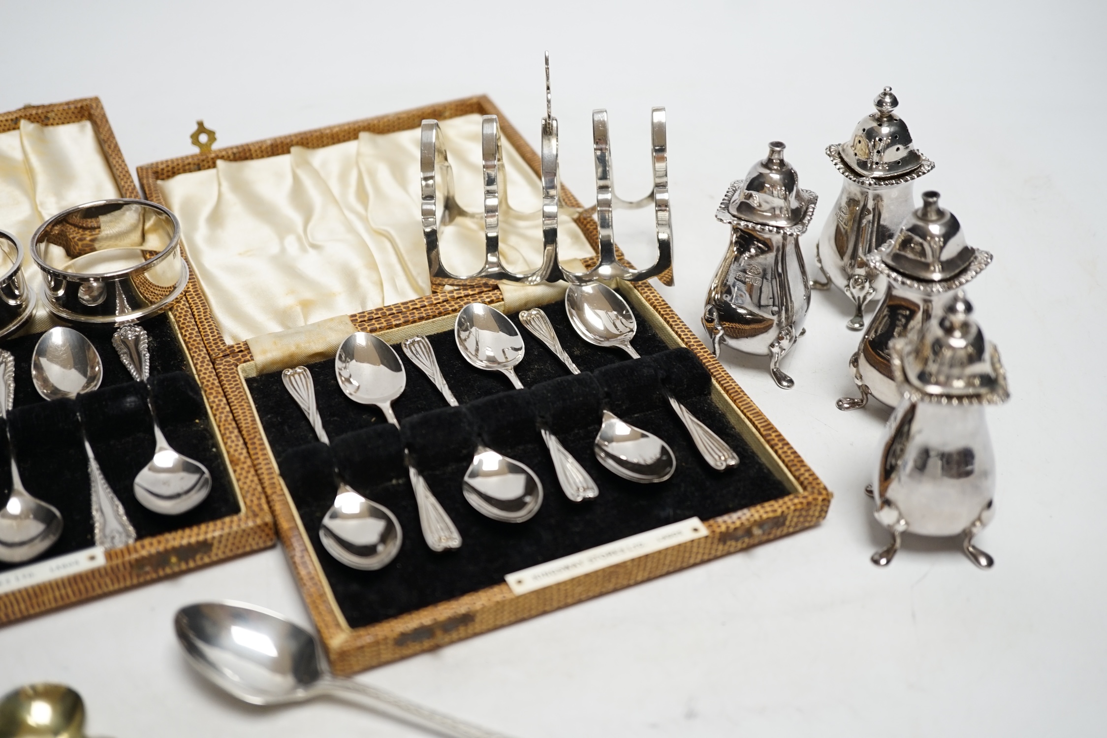 Two cased sets of six silver coffee spoons, a set of four silver condiments, two silver napkin - Image 4 of 6