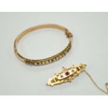 An Edwardian 9ct gold ruby and diamond chip set hinged bangle and a similar yellow metal, ruby and