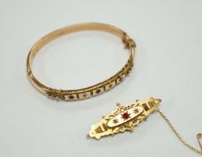 An Edwardian 9ct gold ruby and diamond chip set hinged bangle and a similar yellow metal, ruby and