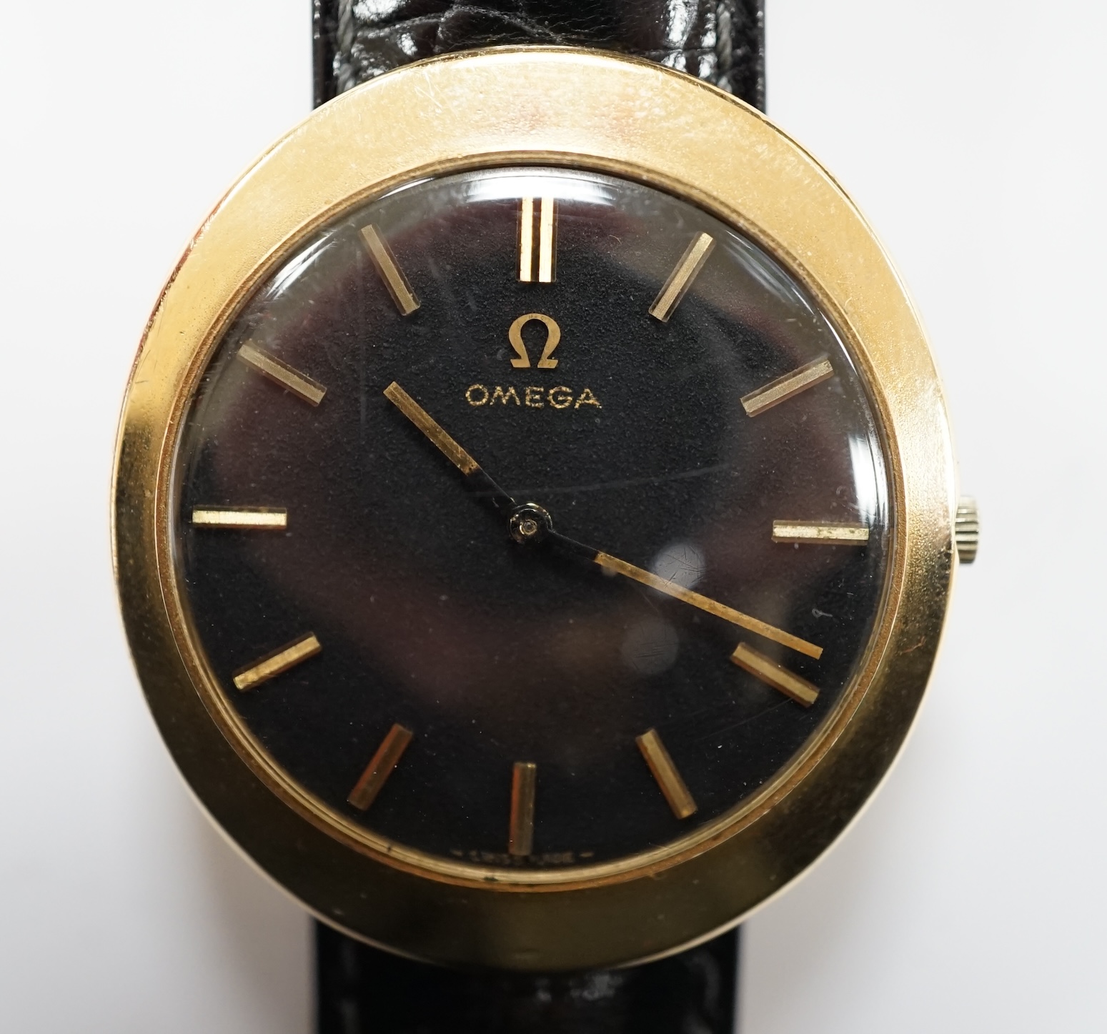 A gentleman's 9ct gold black dial manual wind wrist watch, with Omega box.