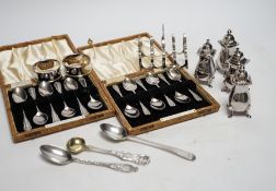 Two cased sets of six silver coffee spoons, a set of four silver condiments, two silver napkin
