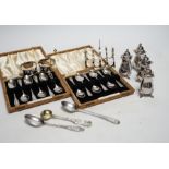 Two cased sets of six silver coffee spoons, a set of four silver condiments, two silver napkin