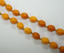 A long single strand oval amber bead necklace, 156cm, gross weight 89 grams.