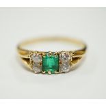 An 18ct, single stone emerald and four stone diamond cluster set ring, size M, gross weight 2.2