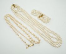 Two Cultured pearl necklaces including a triple strand with yellow metal and sapphire set clasp,