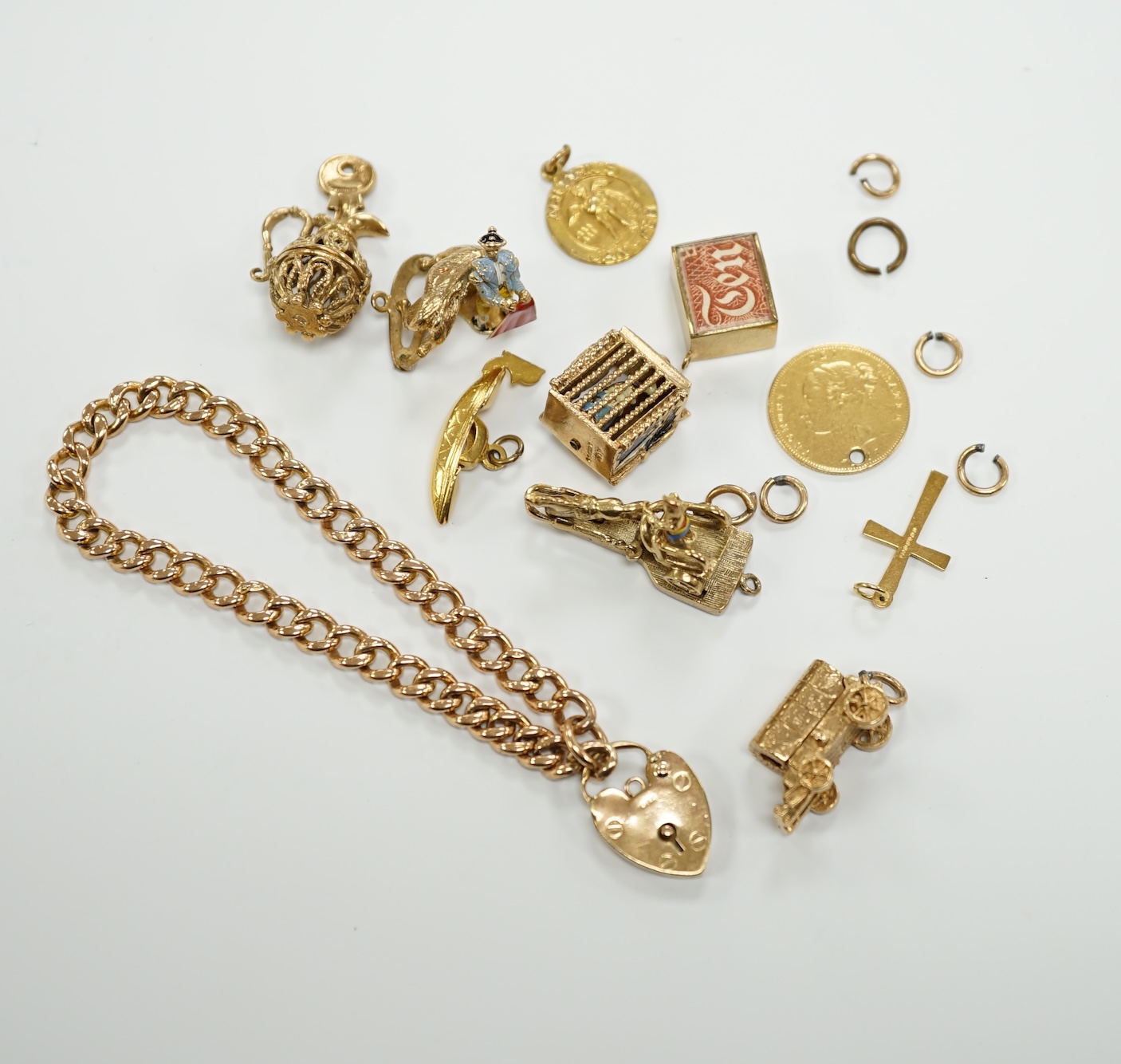 A 9ct gold curb link bracelet and eleven assorted mainly 9ct gold loose charms, gross weight 56.3