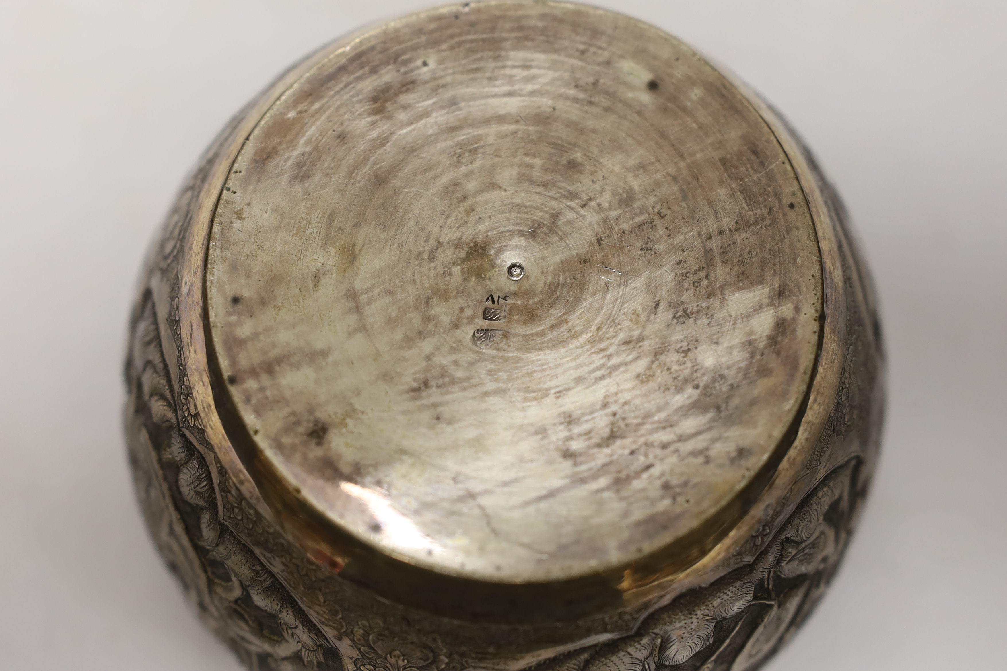 A Persian white metal bowl decorated in relief with animals and flowers, indistinct marks to the - Image 5 of 5