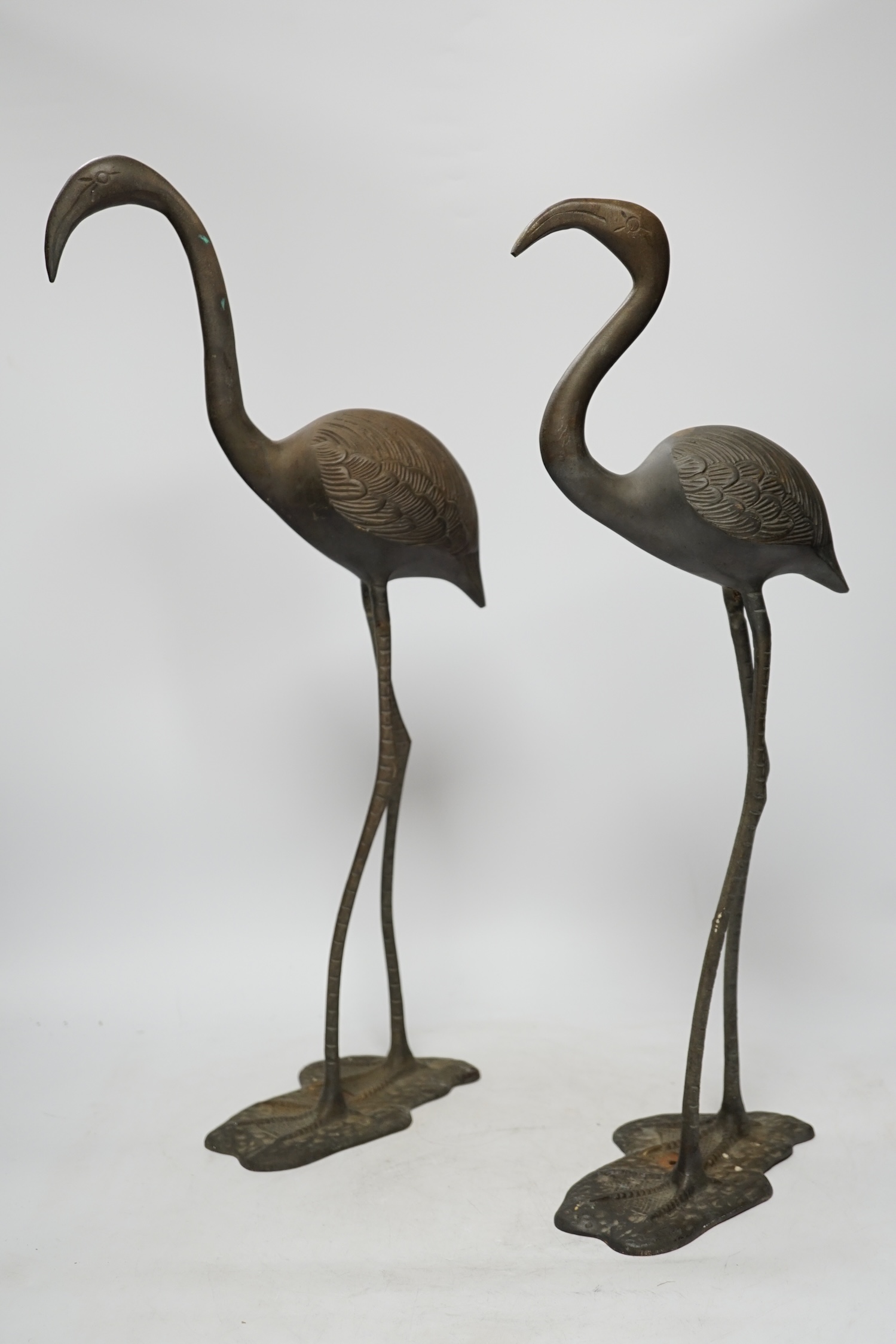 A pair of brass cranes, a pair of brass chamber sticks another chamberstick and a bowl, tallest 53cm