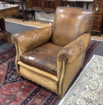 An early 20th century French studded tan leather club chair, width 64cm, depth 72cm, height 77cm