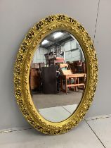 An oval gilt composition wall mirror, width 82cm, height 114cm