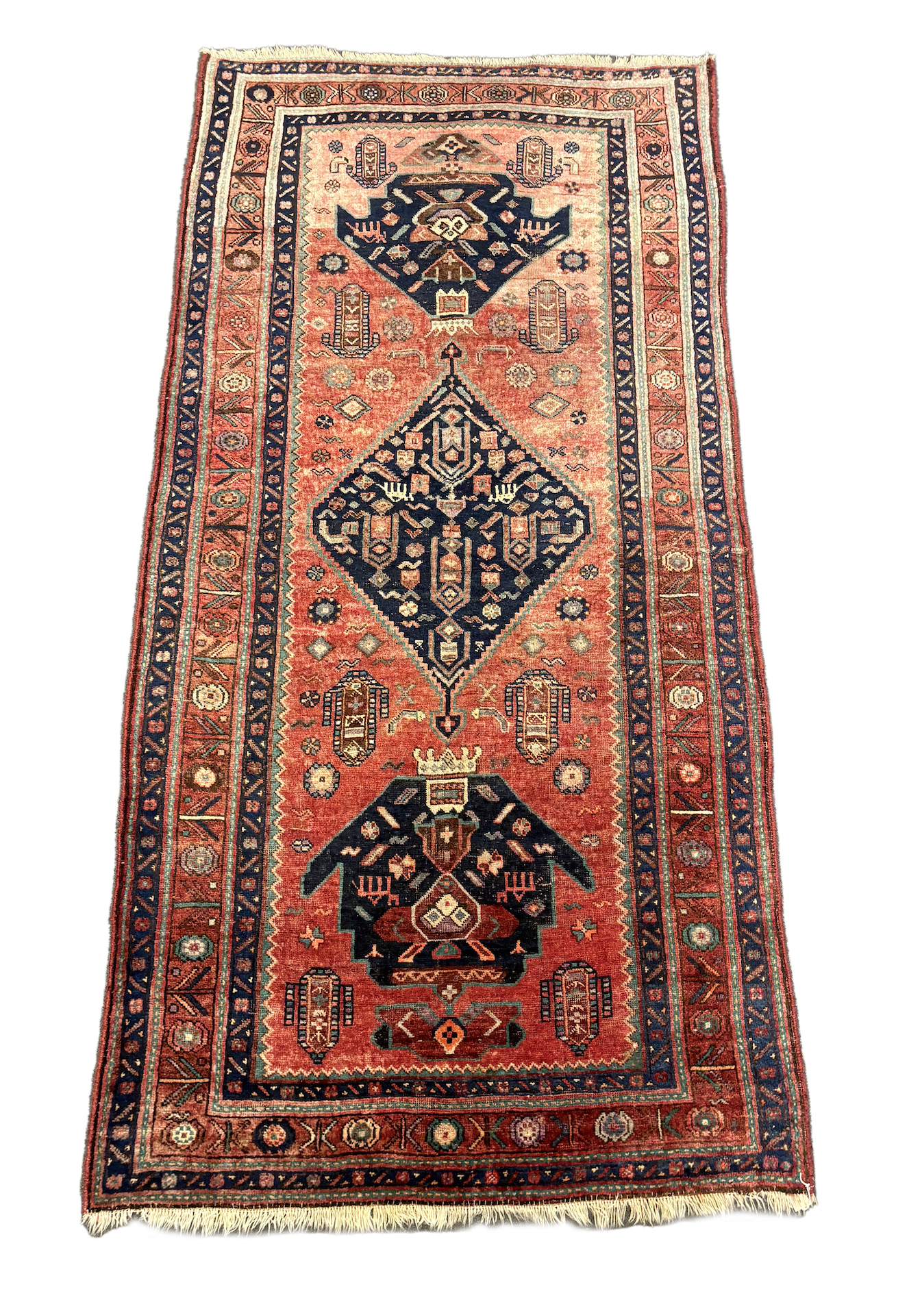 An Heriz red ground medallion rug with triple medallions on a brick red ground, multi bordered,
