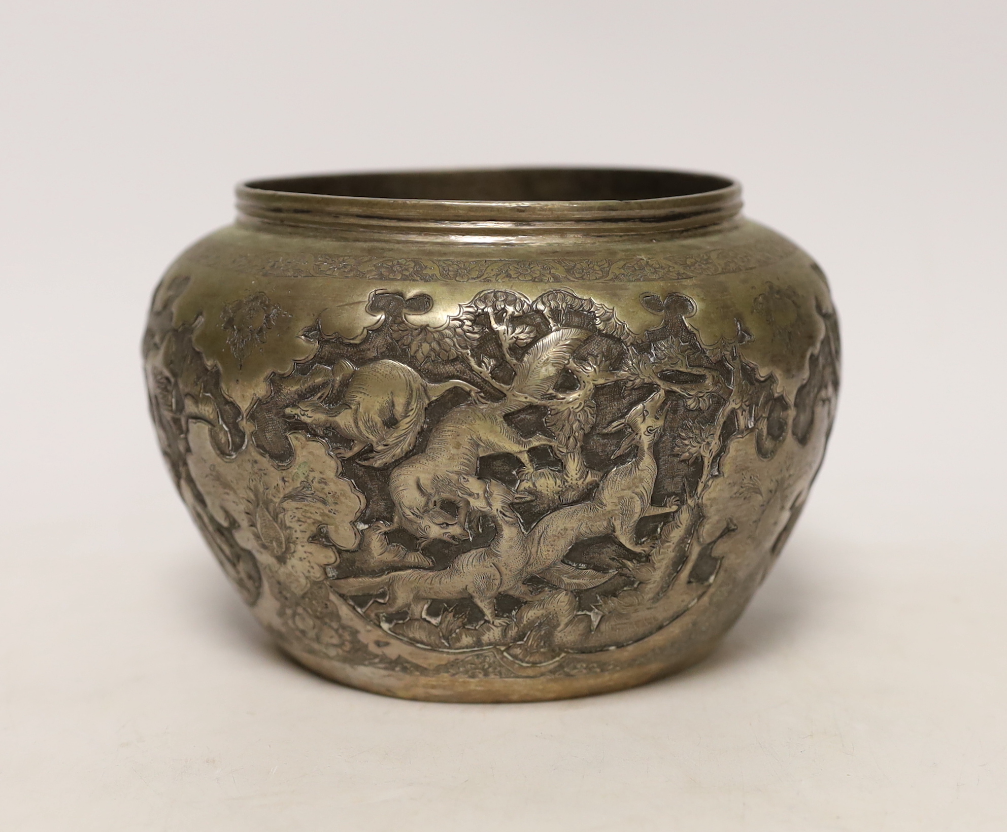A Persian white metal bowl decorated in relief with animals and flowers, indistinct marks to the