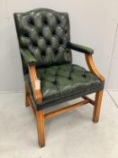 A reproduction buttoned green leather Gainsborough style desk chair, width 59cm, depth 52cm,