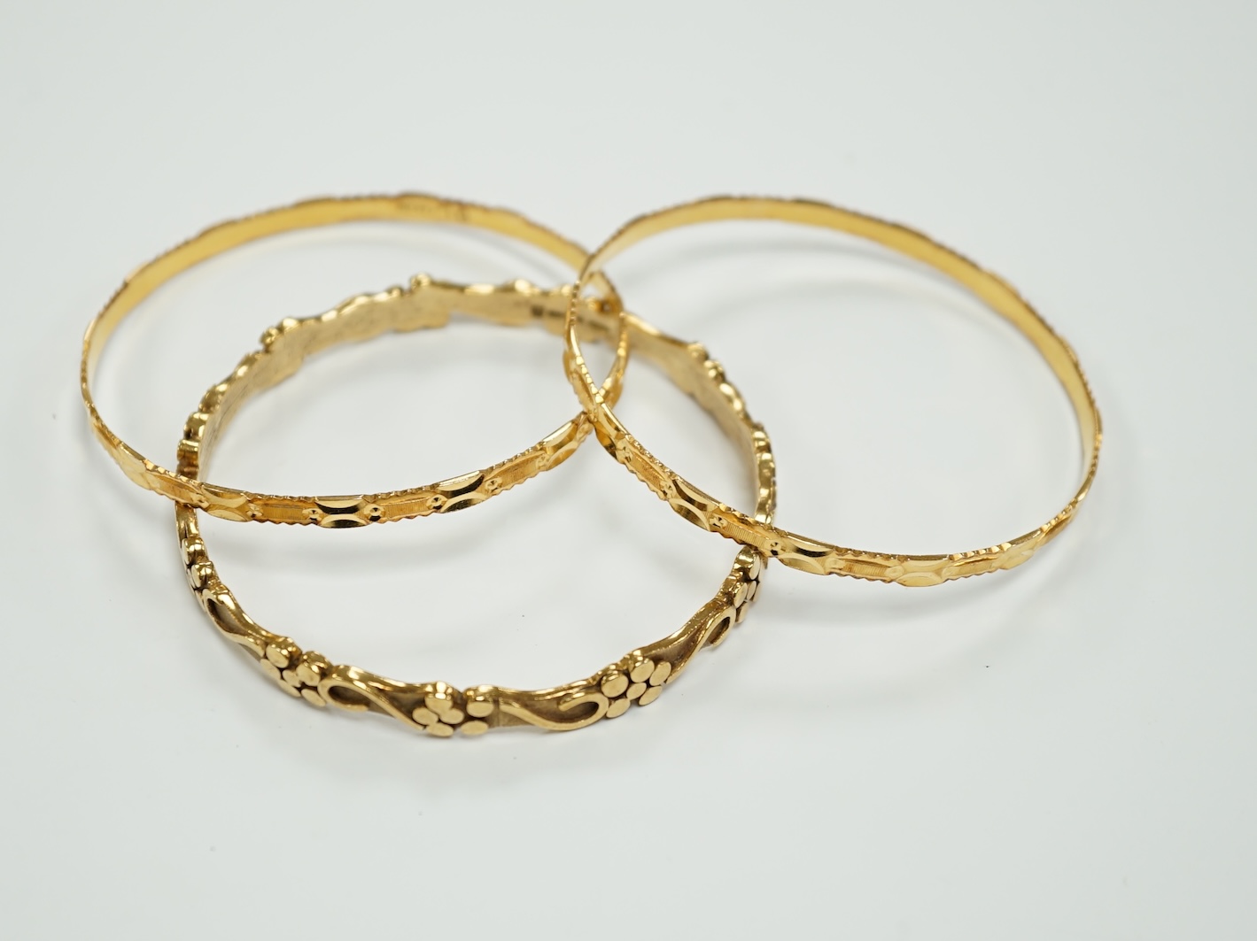 Two 22k bangles, 19.6 grams and a 9ct gold bangle, 20.6 grams.