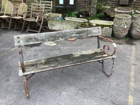 A slatted wrought iron garden bench, width 147cm, height 74cm