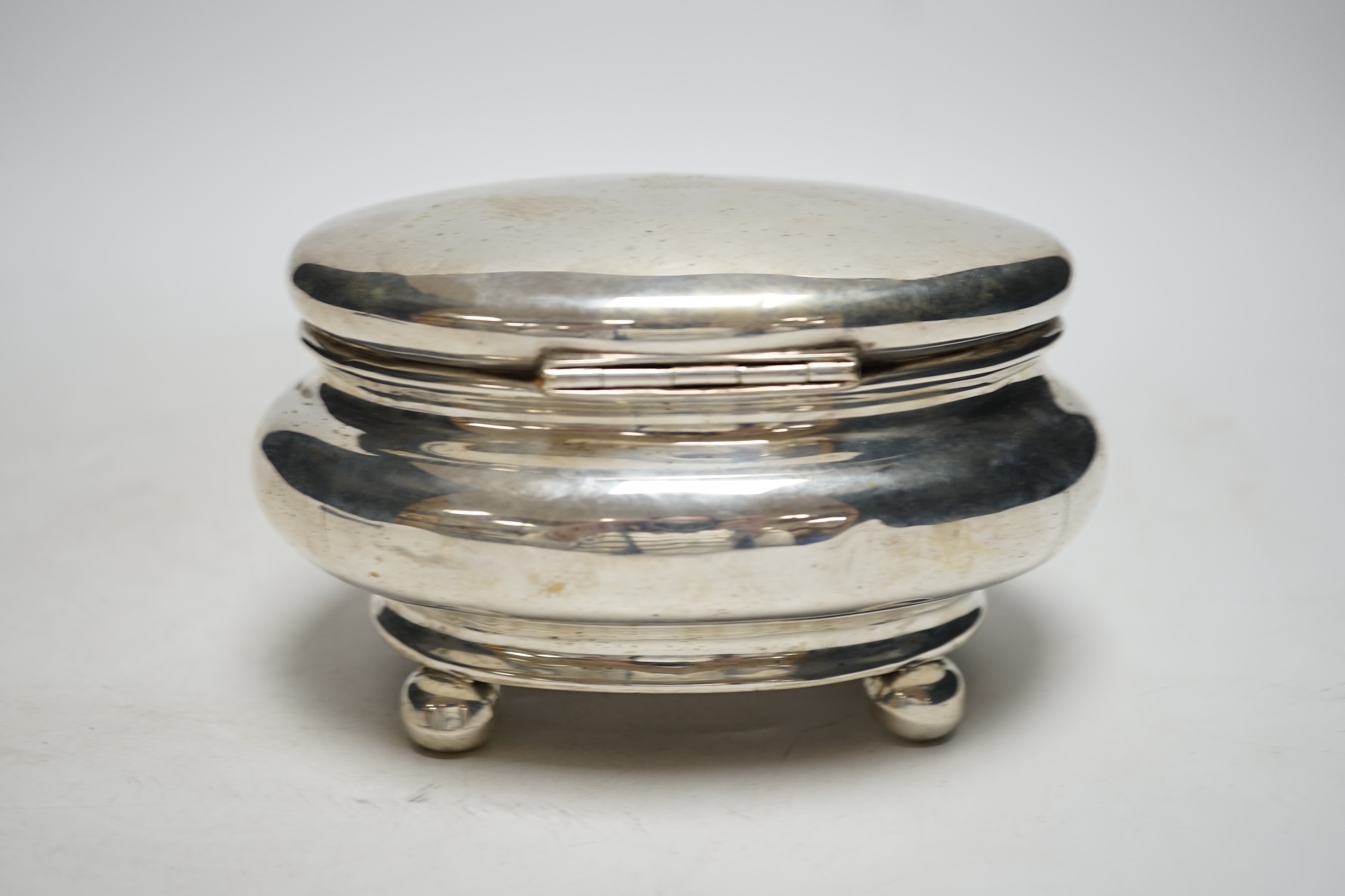 A 19th century German? white metal oval tea caddy, on bun feet, lacking key, width 16cm, 8.8oz. - Image 2 of 3