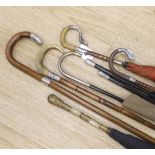 Various vintage umbrellas and walking sticks, three with silver mounted handles and two ebonised