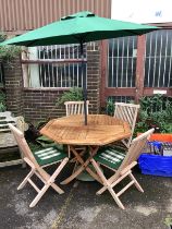 An octagonal weathered teak folding garden table, width 120cm, height 76cm four teak folding