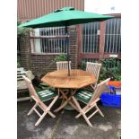 An octagonal weathered teak folding garden table, width 120cm, height 76cm four teak folding