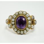 A Victorian yellow metal seed pearl and amethyst set oval cluster ring, size L, gross weight 3.7