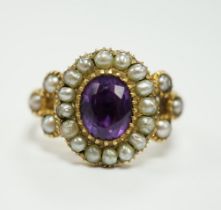 A Victorian yellow metal seed pearl and amethyst set oval cluster ring, size L, gross weight 3.7